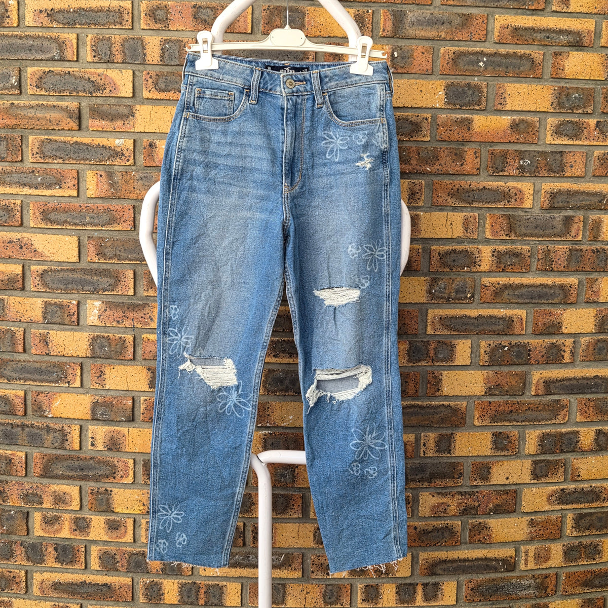 Jean mom Hollister femme bleu clair, taille haute, délavage floral et déchirures aux genoux, vue de face