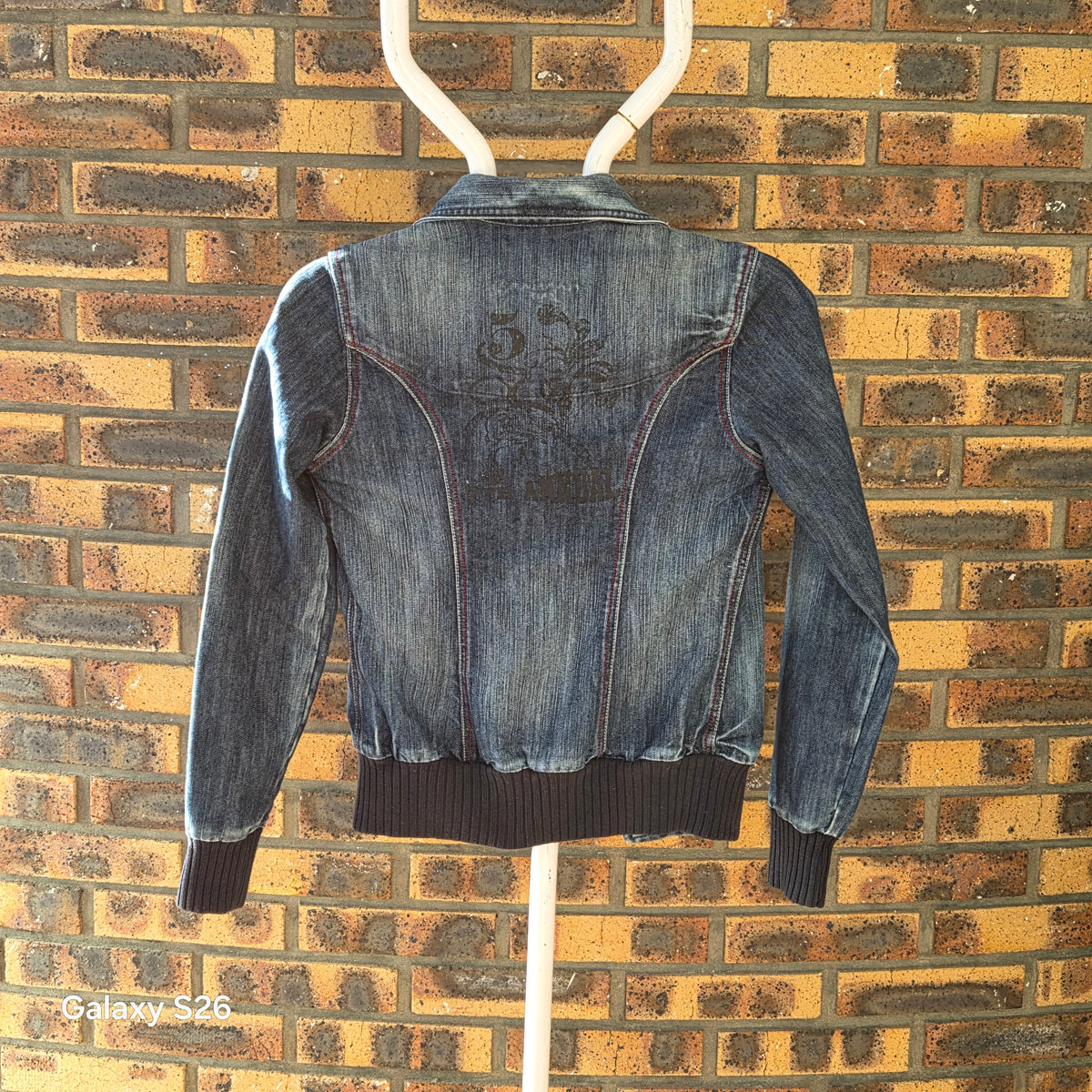 Veste en jean Naf Naf femme taille S, vue de dos avec broderie décorative et finitions en bord-côte bleu marine.